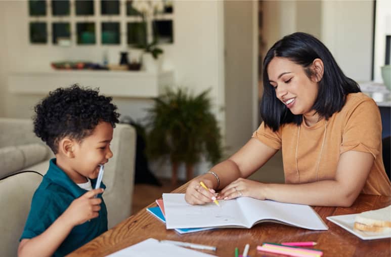 Mom showing her son how to draw on a piece of paper